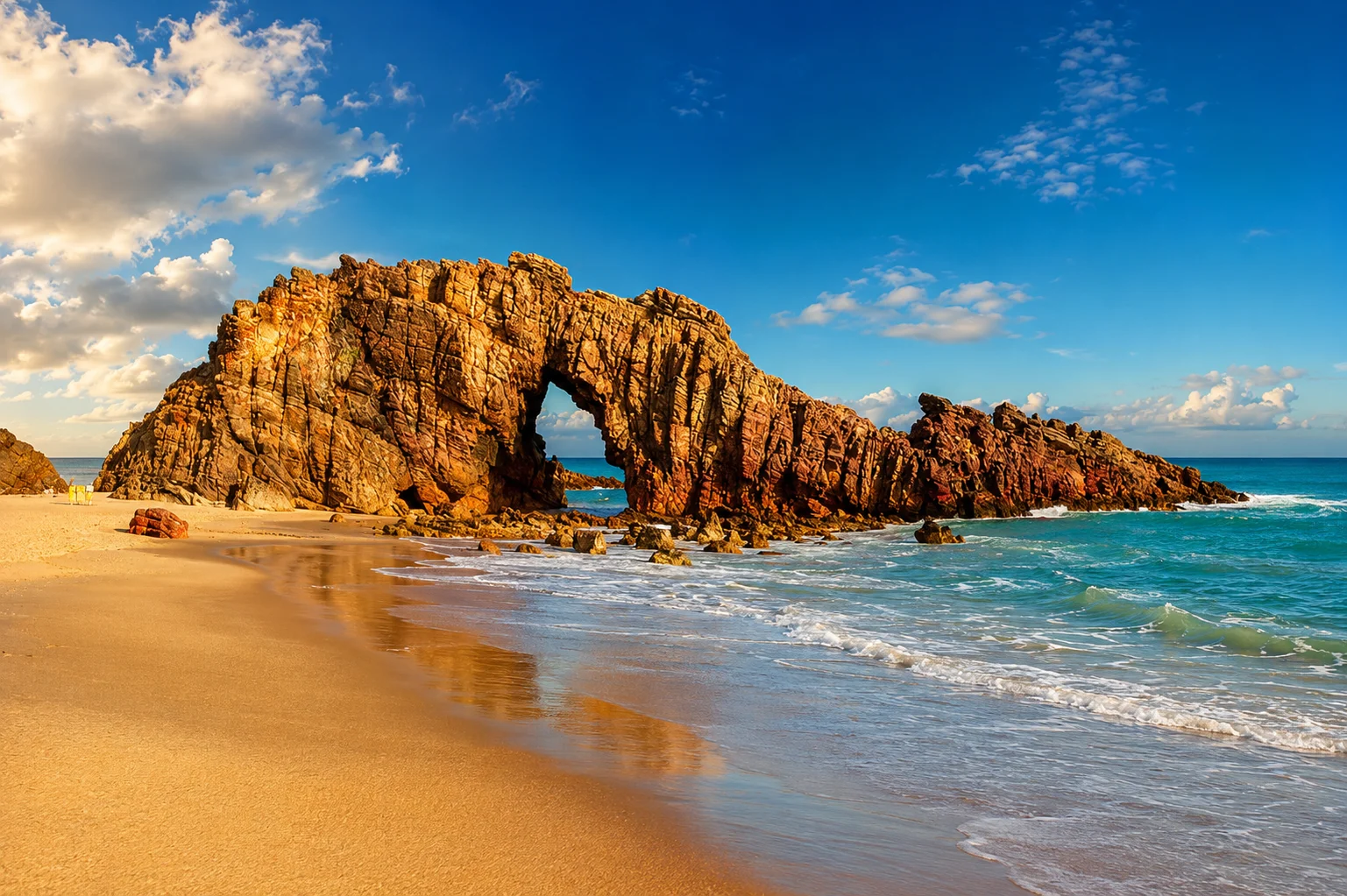 Pedra Furada rock arch on the beach at Jericoacoara, Ceará, at golden hour
