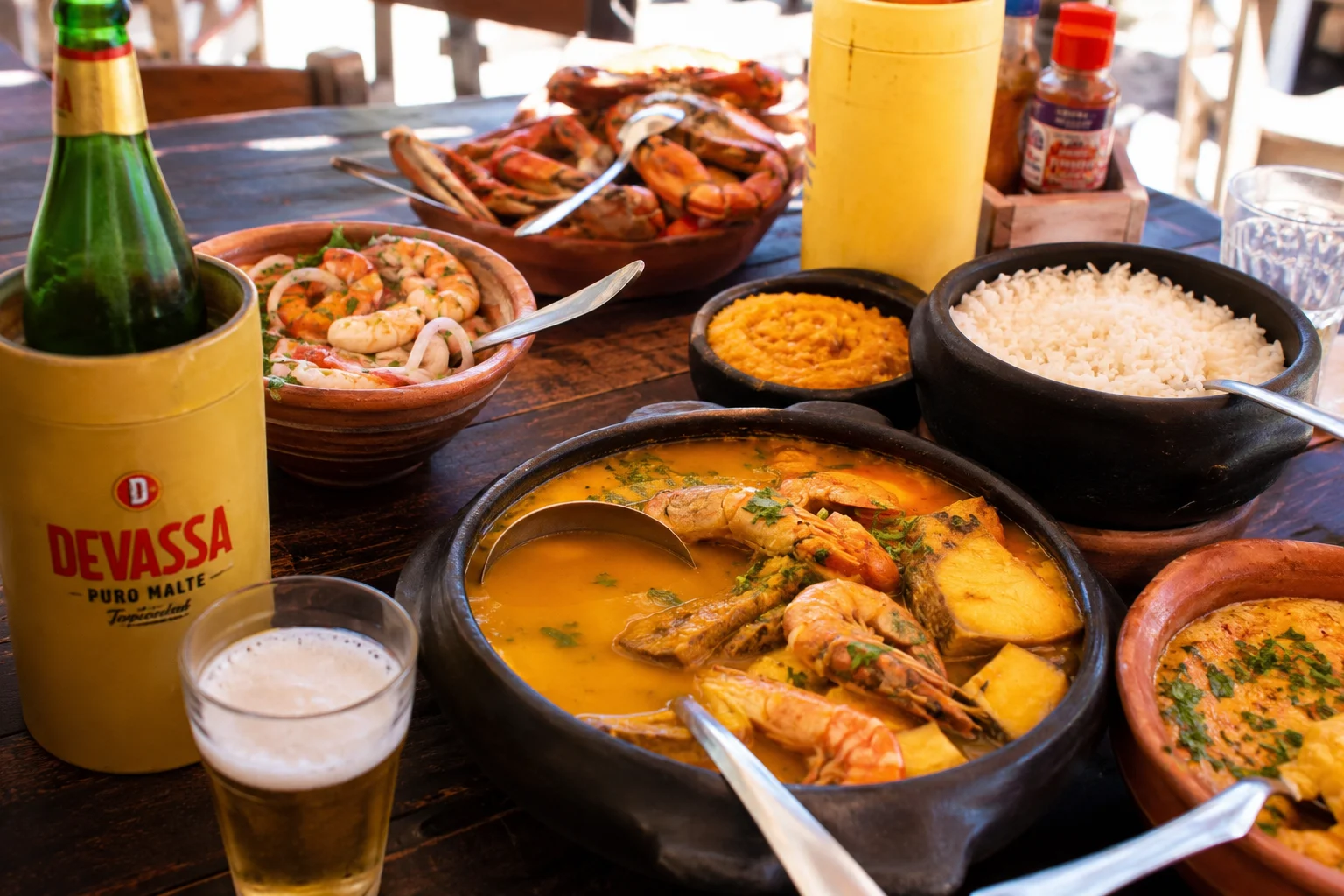 Traditional Fortaleza seafood spread with shrimp moqueca, grilled crab, rice and cold beer