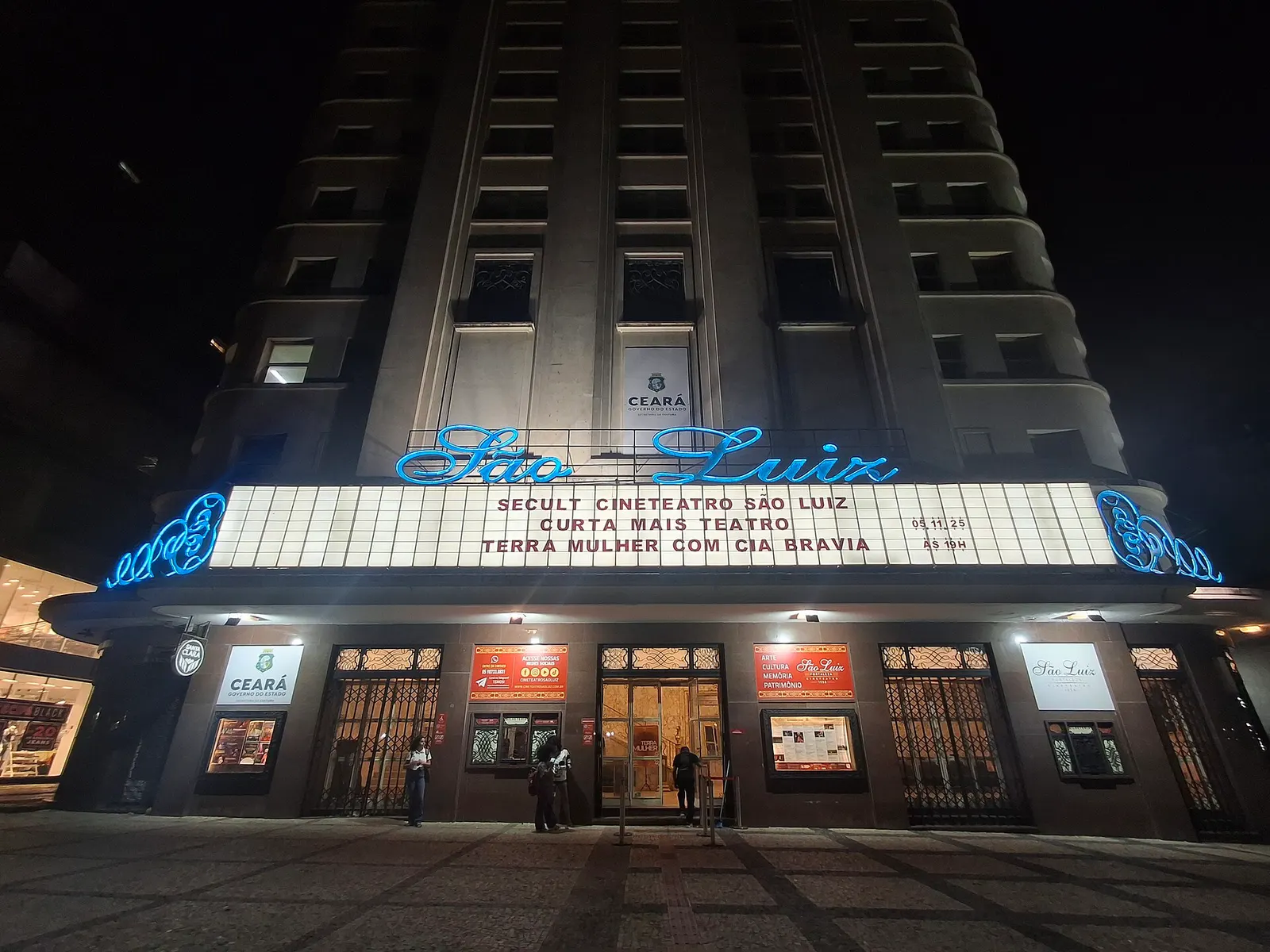 Die beleuchtete Fassade des Cineteatro São Luiz bei Nacht mit blauer Leuchtschrift São Luiz