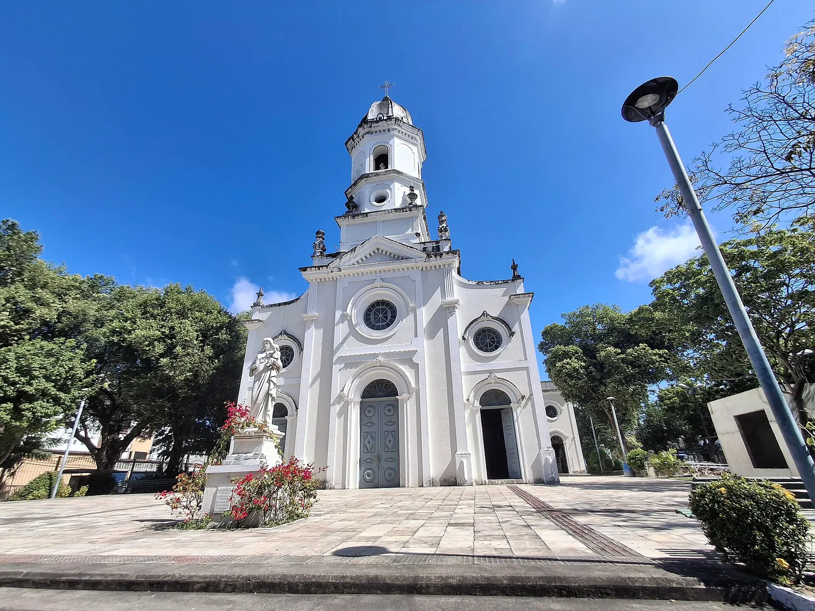 La facciata bianca con torre dell’Igreja do Carmo dietro una piazza alberata