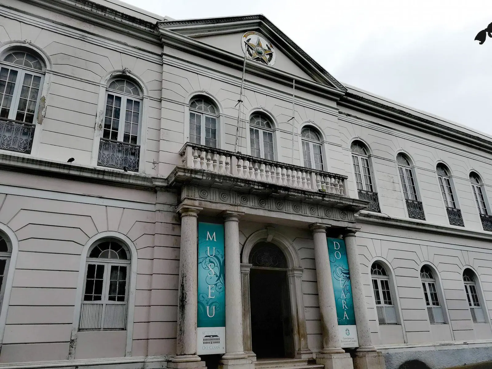 La fachada blanca del Palacete Senador Alencar con pancartas del Museu do Ceará